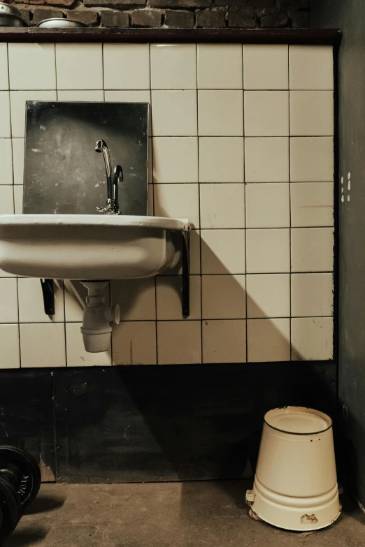 a bathroom with a sink and a trash can, an album cover, by Jan Tengnagel, unsplash, ignant, kreuzberg, 1980s photo, watertank