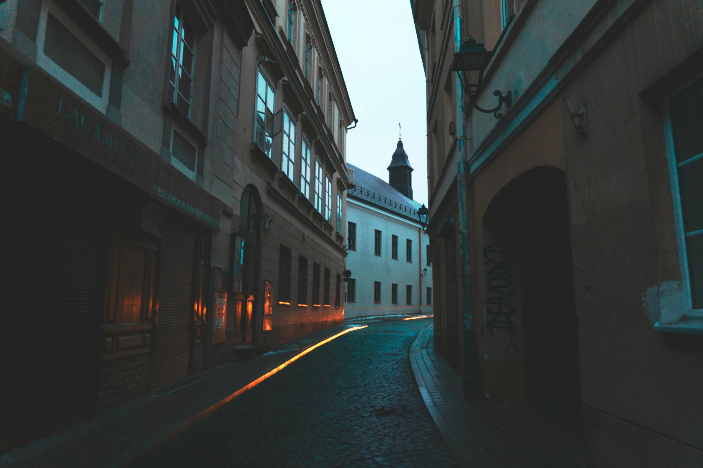 a narrow cobblestone street with a church steeple in the background, by Adam Szentpétery, unsplash contest winner, baroque, lines of lights, soft light dull mood, twisting streets, street of teal stone