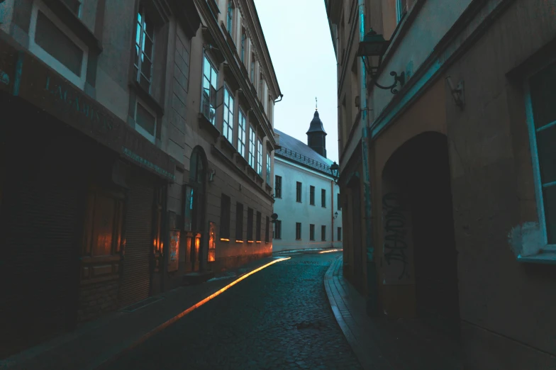 a narrow cobblestone street with a church steeple in the background, by Adam Szentpétery, unsplash contest winner, baroque, lines of lights, soft light dull mood, twisting streets, street of teal stone
