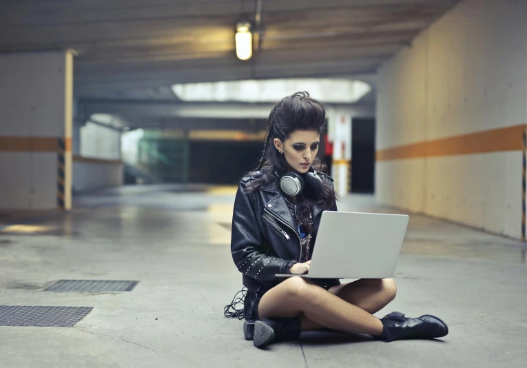 a woman sitting on the ground with a laptop, a photo, inspired by Elsa Bleda, trending on pexels, graffiti, mall goth, gaming, rocking out, ariana grande photography