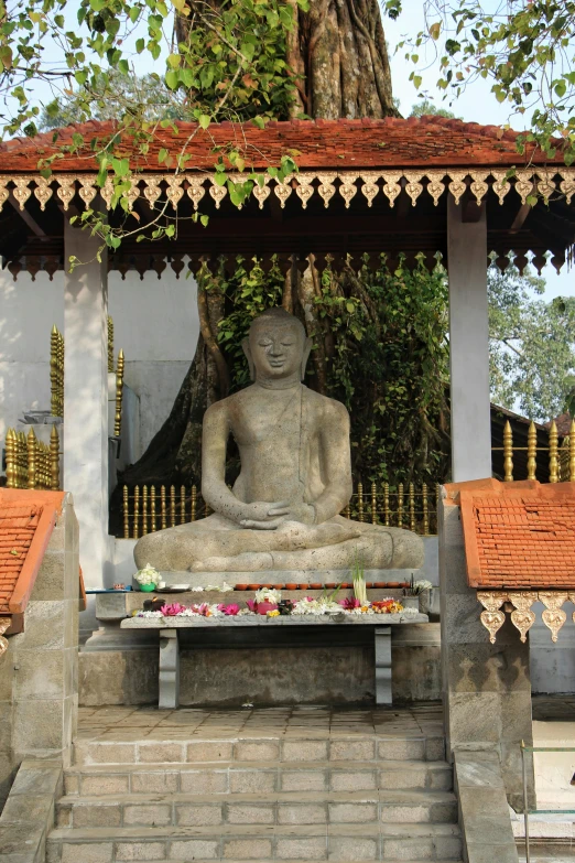 a statue of a person sitting under a tree, in a temple, nivanh chanthara, monuments, public art
