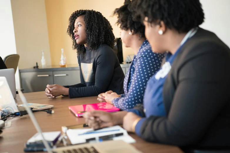 a group of women sitting at a table with laptops, by Carey Morris, pexels, panel of black, in a meeting room, three women, profile image
