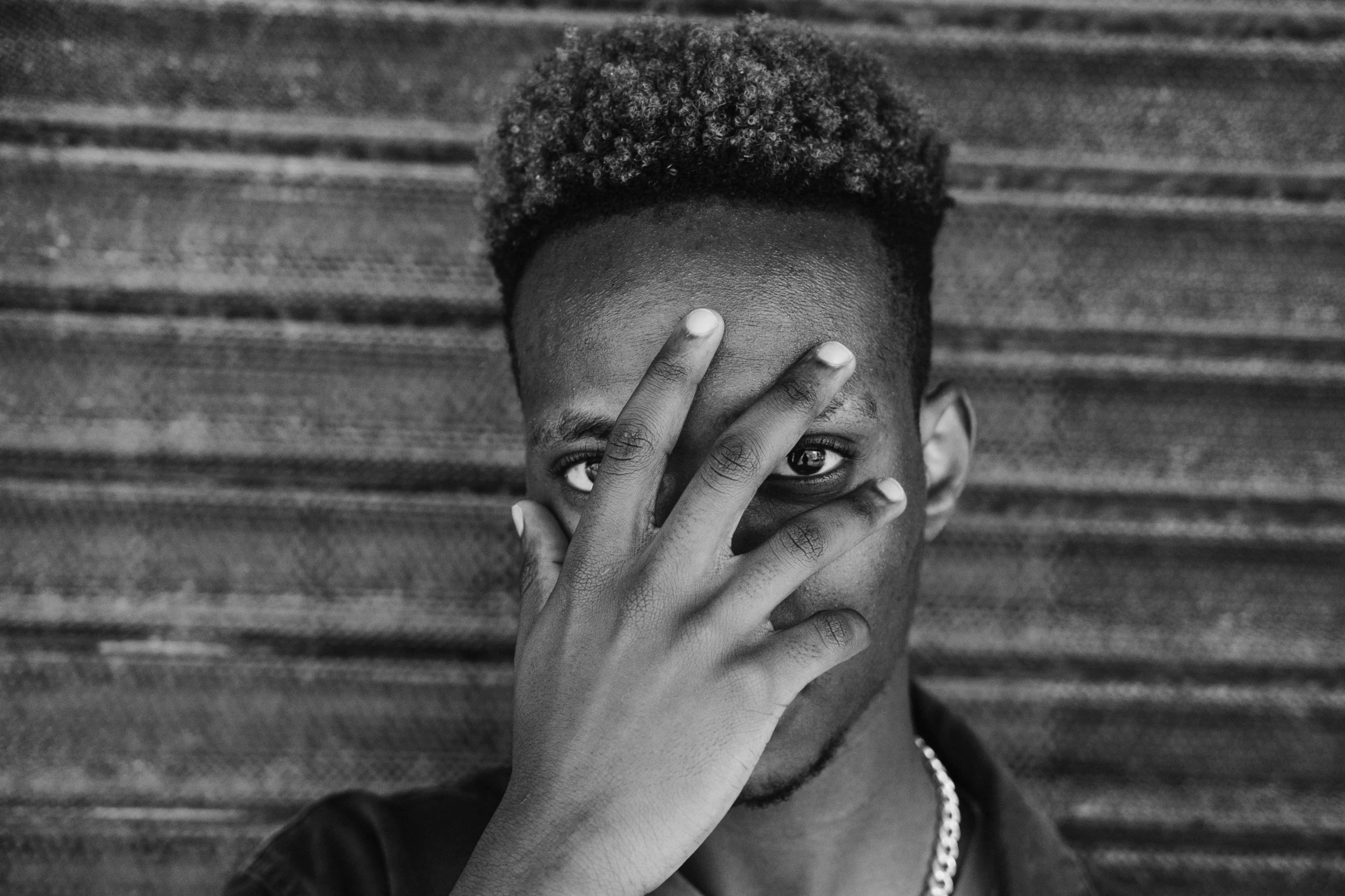 a man covering his face with his hands, a black and white photo, by Alexis Grimou, pexels, afro tech, portrait of a sharp eyed, playboi carti portrait, hand on his cheek