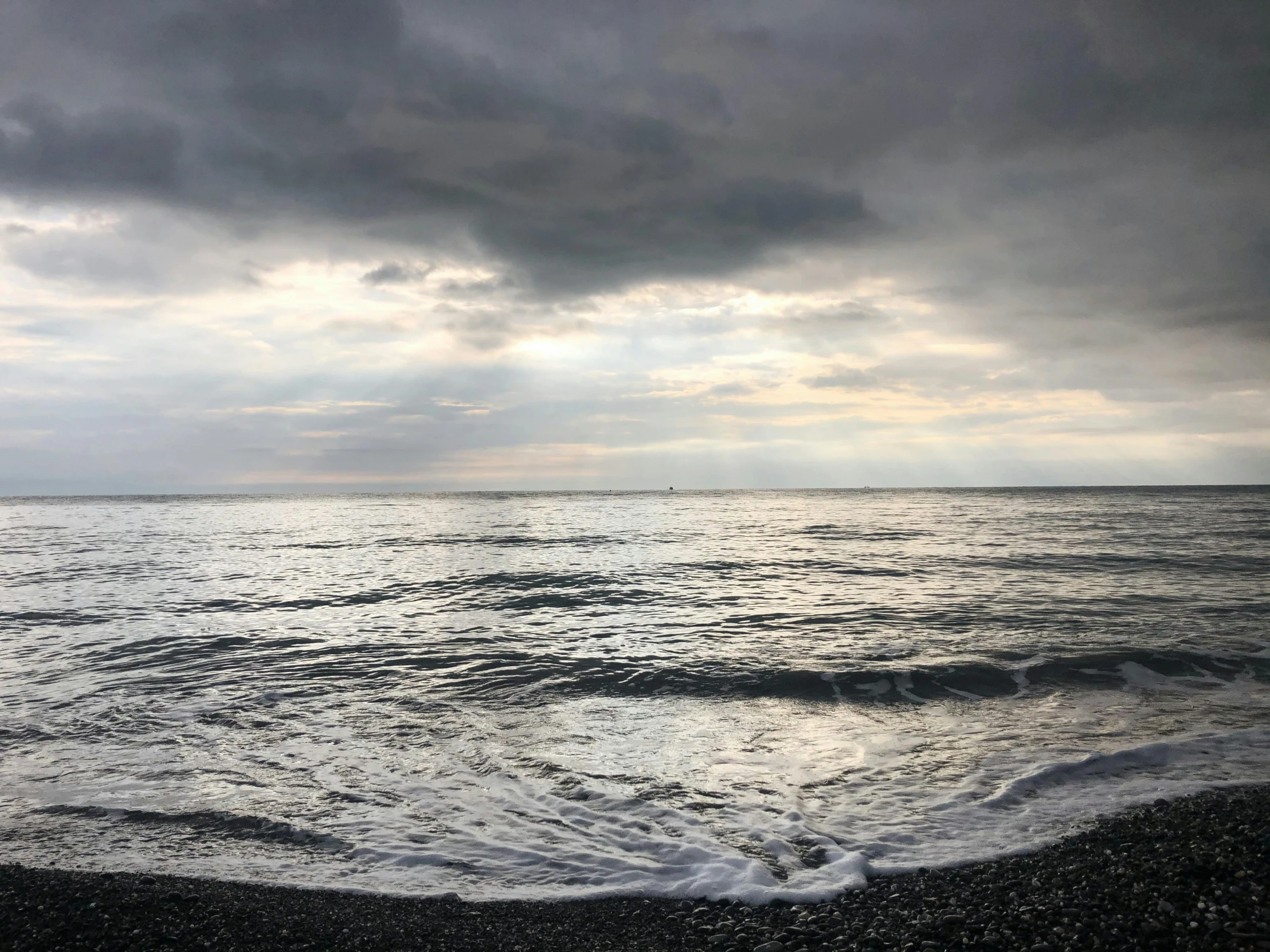 a large body of water under a cloudy sky, an album cover, by Alison Watt, unsplash, storming the beaches of normandy, early evening, grey, gulf of naples