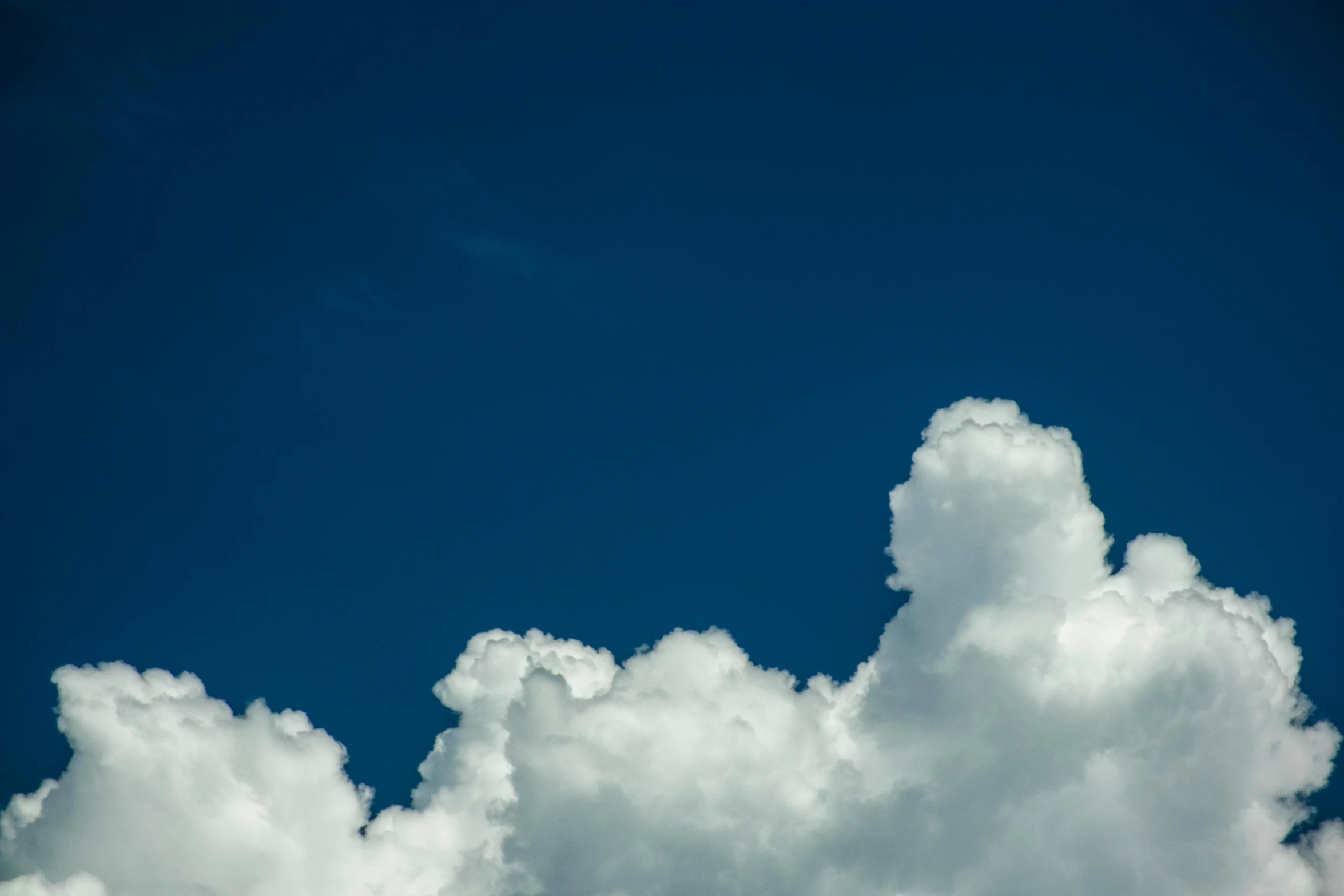 a plane flying through a cloud filled blue sky, unsplash, minimalism, towering cumulonimbus clouds, portrait photo, ignant, cloudless-crear-sky