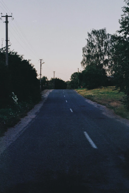 a street sign sitting on the side of a road, an album cover, by Attila Meszlenyi, unsplash, postminimalism, late summer evening, country road, low quality photo, early 2000s