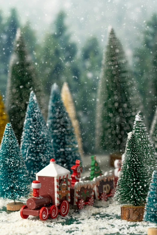 a toy train traveling through a snow covered forest, inspired by Ernest William Christmas, model trees, a quaint, santa, zoomed in