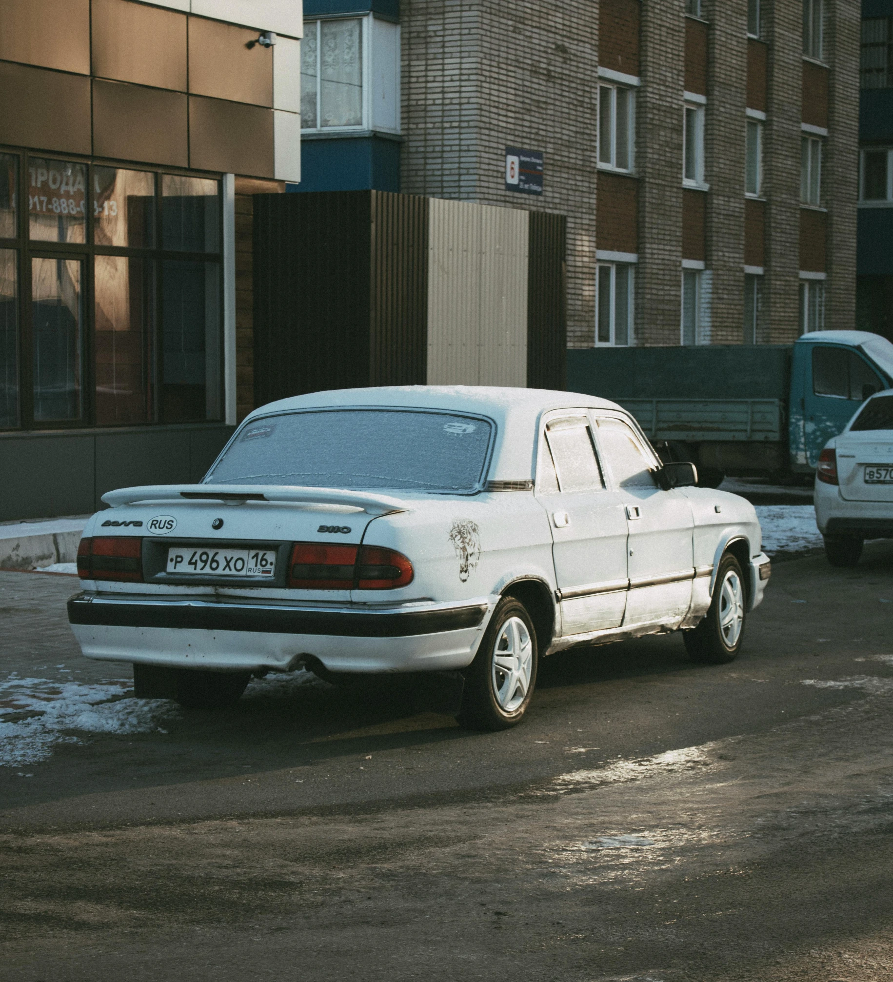 a white car parked on the side of a road, by Attila Meszlenyi, moskvich, former, white