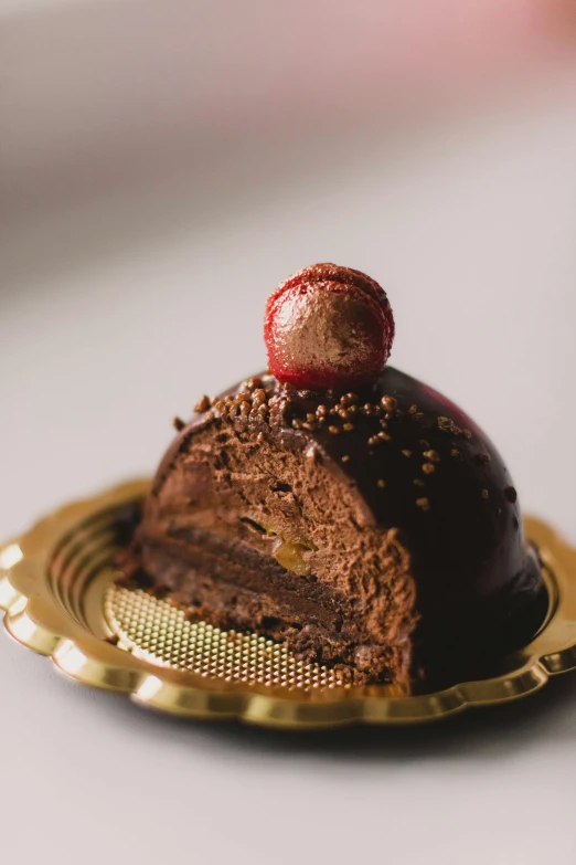 a piece of chocolate cake on a gold plate, inspired by Rudolf von Alt, unsplash, baroque, domes, candy apple, petite, elevation