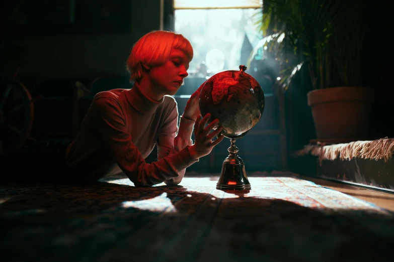 a boy laying on the floor looking at a globe, inspired by Elsa Bleda, unsplash contest winner, magical realism, portrait a woman like reol, lawther sit at table playing dnd, red and cinematic lighting, amy sol in the style of