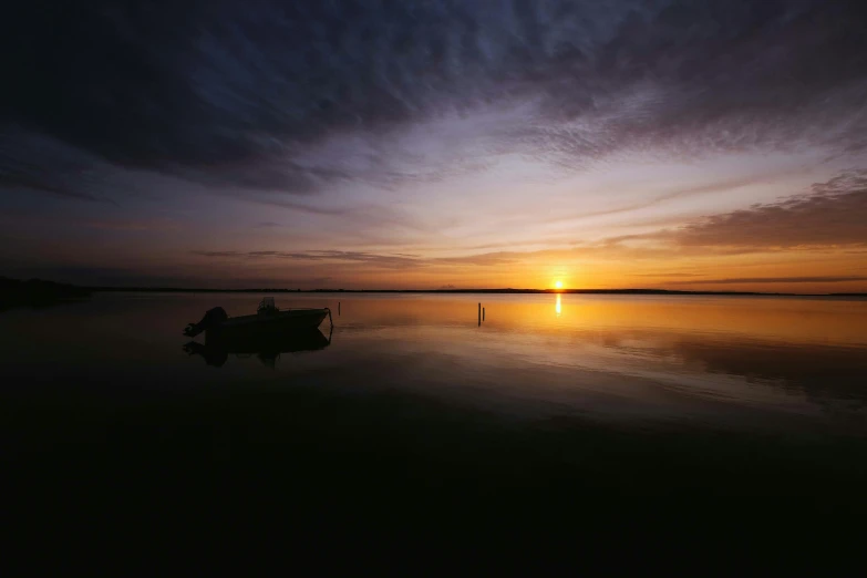 a boat sitting on top of a body of water, by Peter Churcher, unsplash contest winner, romanticism, ((sunset)), lake, low horizon, shot on hasselblad