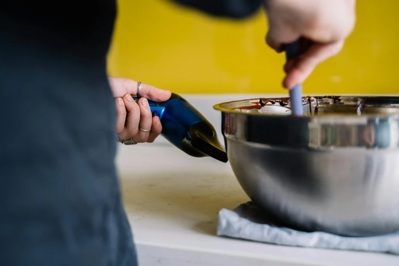 a close up of a person stirring something in a bowl, holding wine bottle, profile image, chocolate, stainless steel