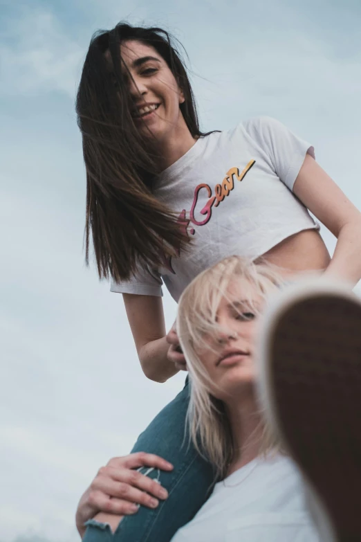 a woman riding on the back of a man, trending on pexels, split dye, two girls, white tshirt, view from ground