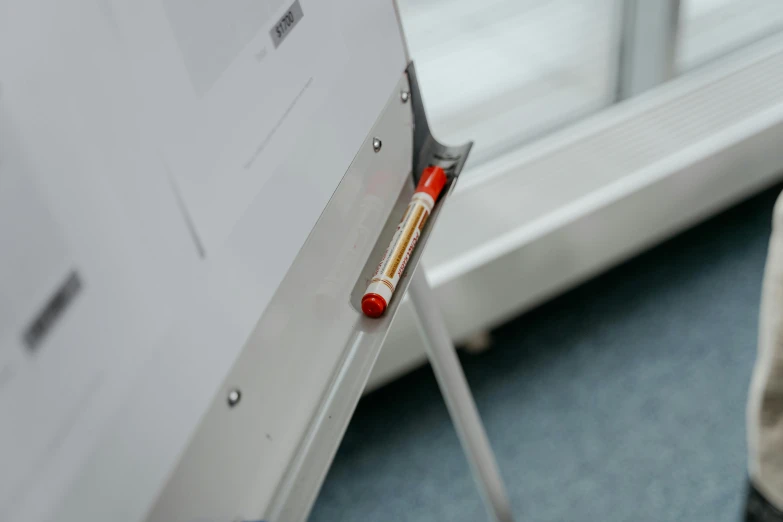 a white board sitting on top of a floor next to a window, a picture, syringe, up-close, performing, image