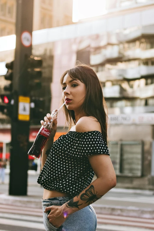 a woman standing on a street corner with a drink in her hand, trending on pexels, soda themed girl, polkadots, charli xcx, square