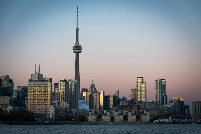 a large body of water with a city in the background, by Carey Morris, pexels contest winner, cn tower, golden hour photo, upright, stacked image