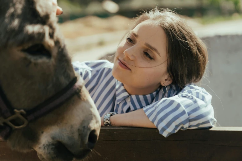 a woman leaning over a fence next to a donkey, a portrait, trending on pexels, avatar image, striped, teenager girl, close up portrait photo