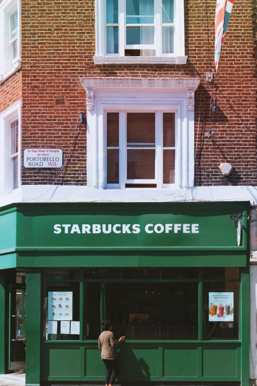 a man standing in front of a starbucks shop, by Paul Bird, trending on unsplash, renaissance, esher, commercial banner, 3/4 view from below, shop front