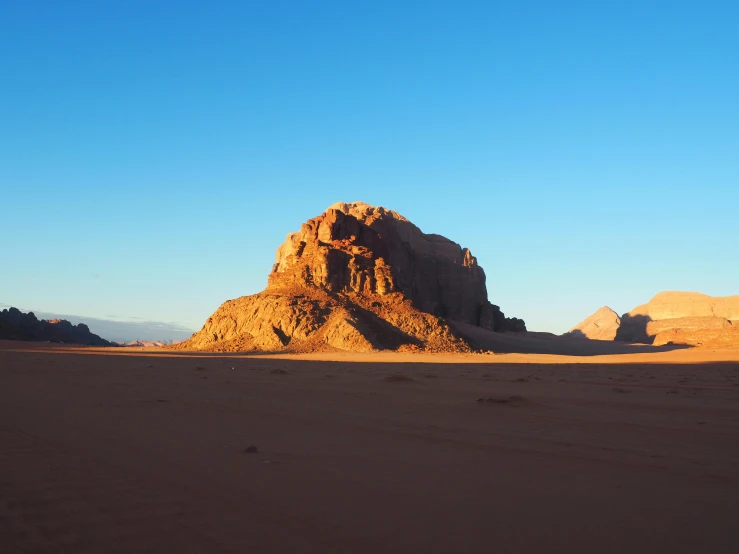 a large rock in the middle of a desert, pexels contest winner, dau-al-set, cloudless sky, medium format, flaming mountain, afternoon