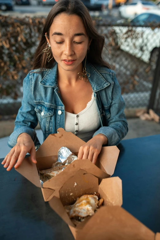 a woman sitting at a table with a box of donuts, by Niko Henrichon, pexels contest winner, renaissance, eating outside, chicken, girl with messy bun hairstyle, square