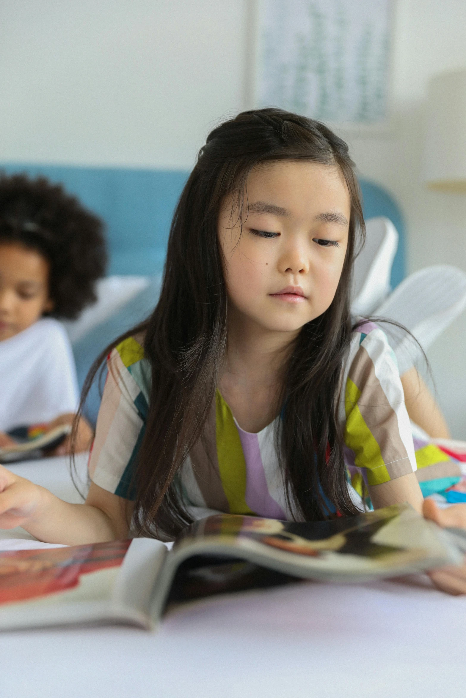 a group of children reading books on a bed, a child's drawing, process art, asian girl with long hair, zoomed in, looking serious, school curriculum expert