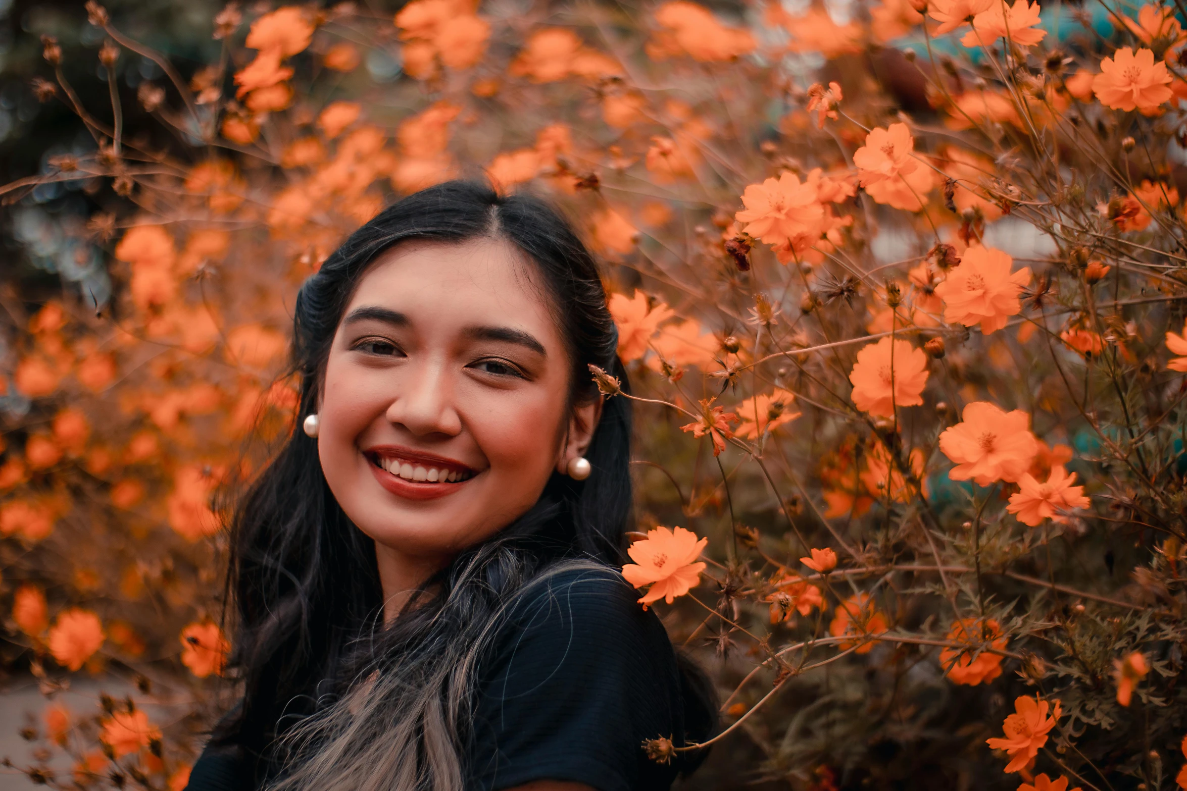 a woman standing in a field of orange flowers, pexels contest winner, realism, smiling :: attractive, south east asian with round face, avatar image, covered in fallen leaves