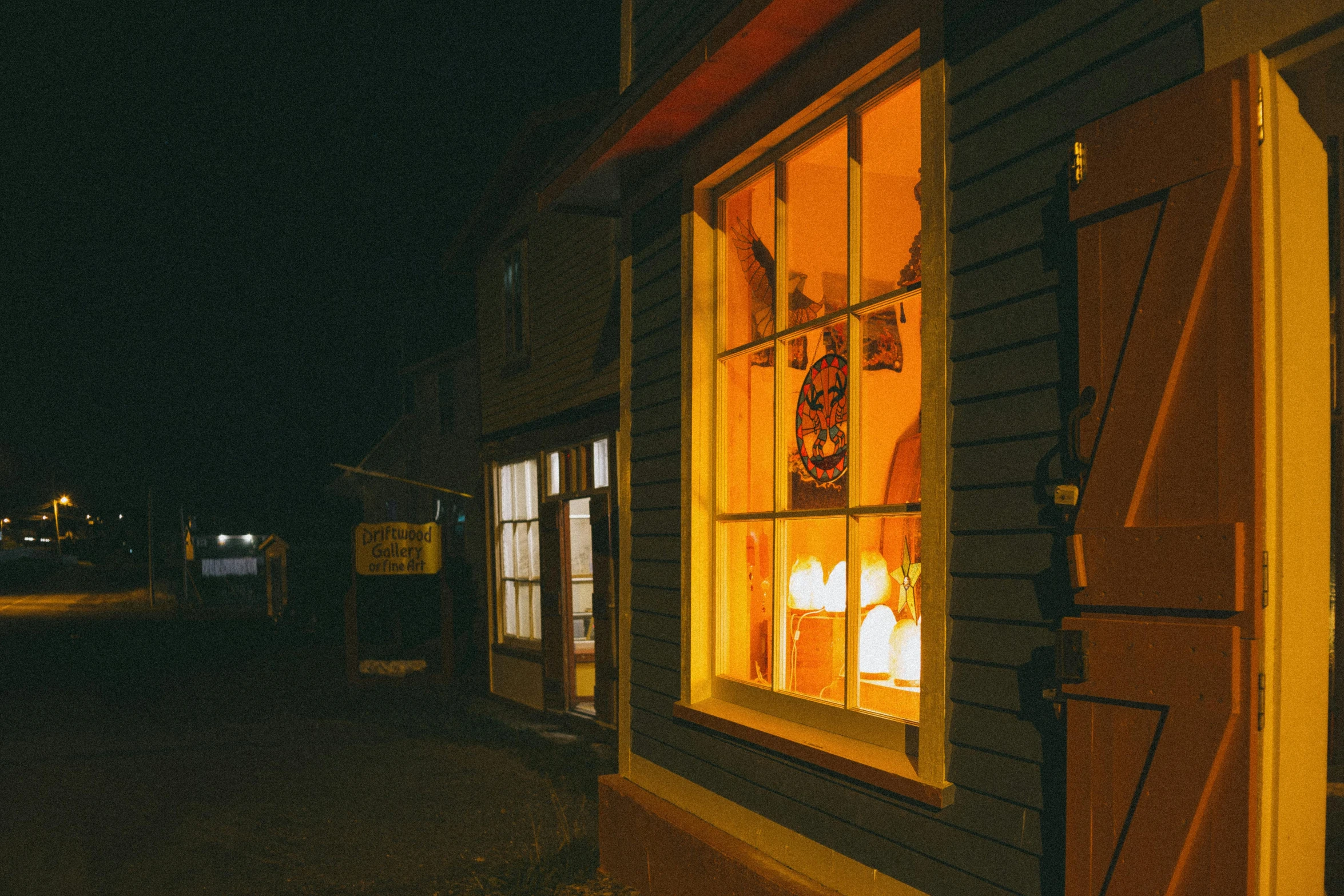 a window that has a lit candle in it, pexels contest winner, shop front, from the outside it looks folksy, nightcap, brown