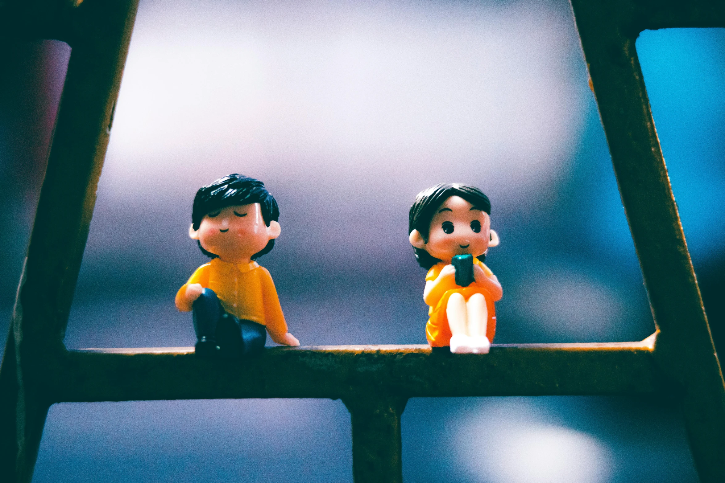 a couple of figurines sitting on top of a window sill, a cartoon, inspired by Nara Yoshitomo, pexels contest winner, on a bridge, plasticine models, sitting in a prison, 3 5 mm slide