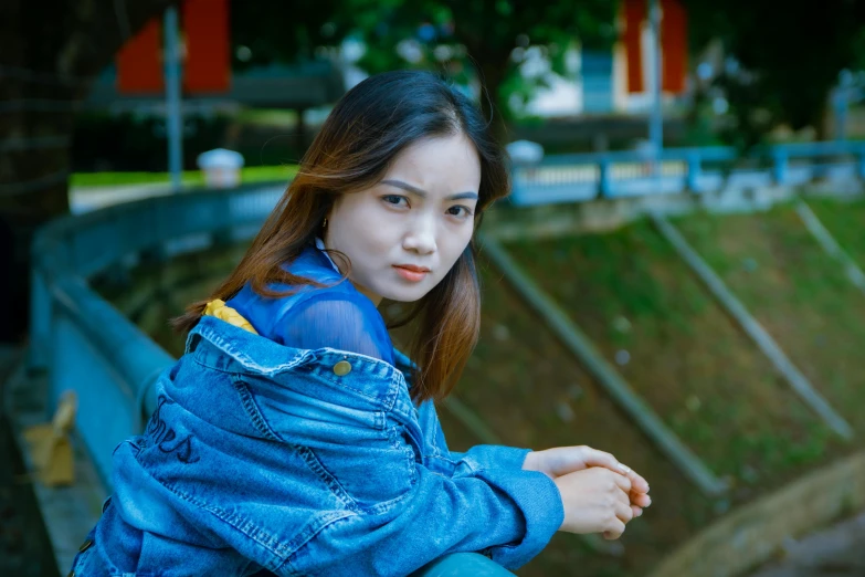a woman sitting on top of a wooden bench, by Bernardino Mei, pexels contest winner, realism, young cute wan asian face, wearing a jeans jackets, close up potrait, wearing blue