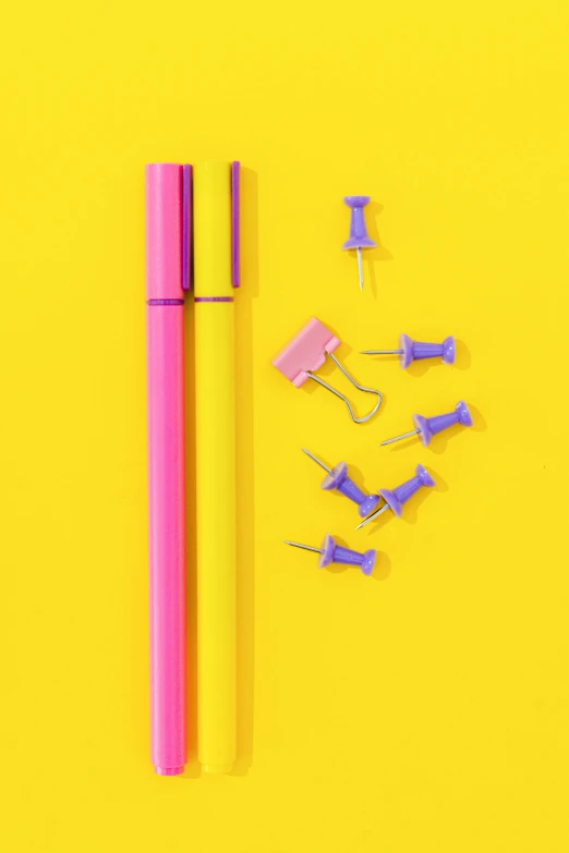 a pink pen sitting on top of a yellow surface, purple tubes, ((neon colors))