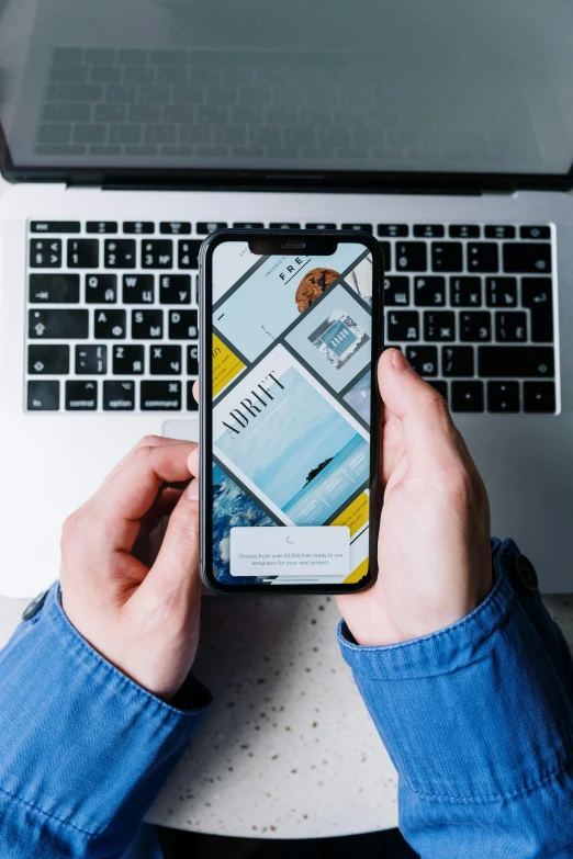 a person holding a cell phone in front of a laptop, a picture, by Niko Henrichon, trending on unsplash, hypermodernism, ios app icon, 2 5 6 x 2 5 6 pixels, blue and yellow color theme, flatlay