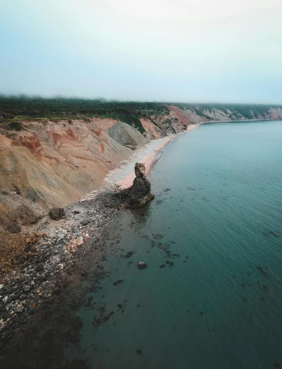 a large body of water next to a cliff, a colorized photo, by Adam Marczyński, pexels contest winner, red sand, 2 5 6 x 2 5 6 pixels, stålenhag, coastline