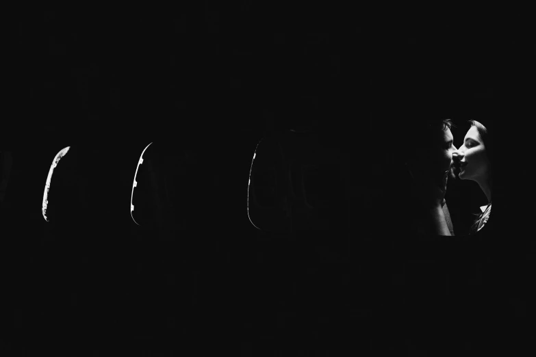 a black and white photo of a couple kissing in the dark, an album cover, by Anna Füssli, unsplash, conceptual art, five planets, ffffound, in roger deakins style, apollo 11