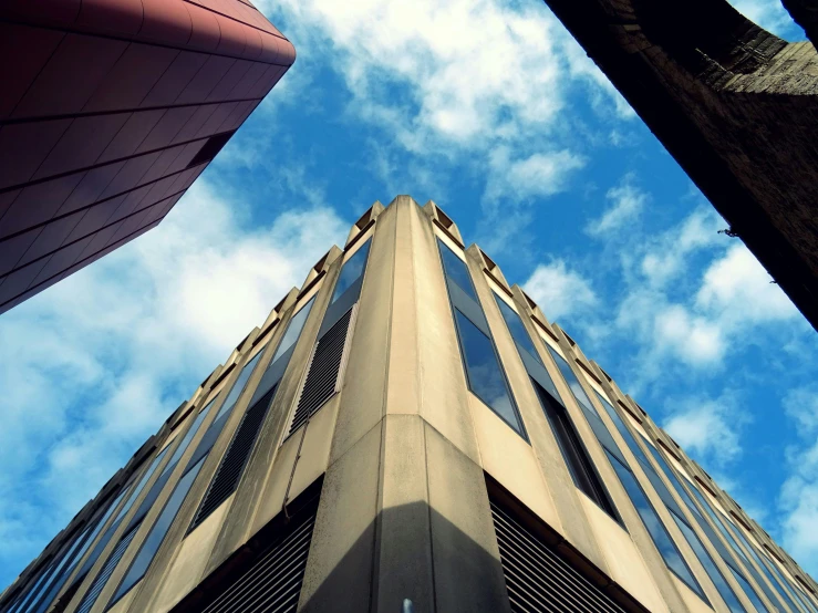 a tall building sitting in the middle of a city, by Lee Loughridge, unsplash, brutalism, face looking skyward, taken in the mid 2000s, looking around a corner, instagram picture