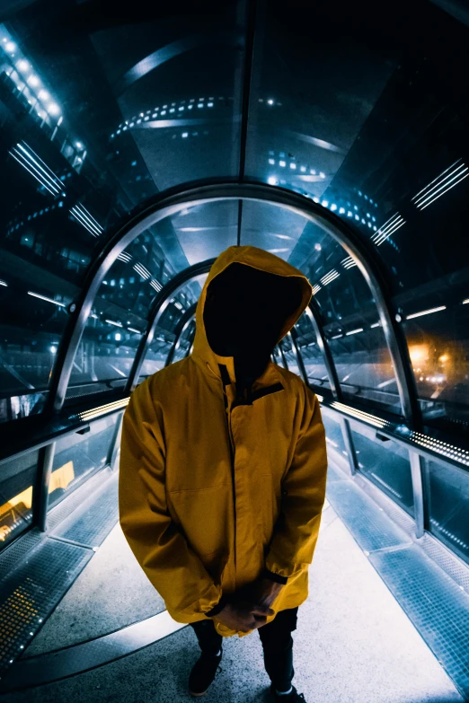 a man in a yellow jacket standing on an escalator, inspired by Beeple, unsplash contest winner, futurism, wearing a dark hood, in front of space station window, dark. no text, standing in a server room