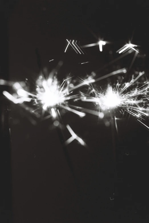 a black and white photo of a sparkler, a black and white photo, pexels, light and space, shot on expired instamatic film, broken lights, instagram post, bright stars