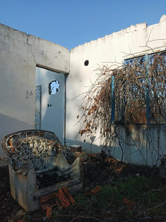 a white building with a broken window and a chair in front of it, vines on the walls, profile image, burned, ((rust))