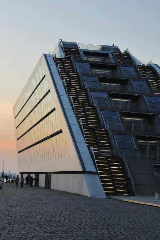 a group of people standing in front of a building, inspired by Tadao Ando, hypermodernism, at the sunset, docks, angled shot, seen from the side
