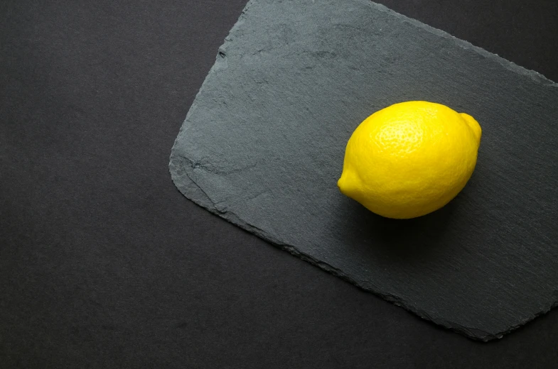 a lemon sitting on top of a piece of slate, by Matthias Stom, trending on unsplash, minimalism, restaurant menu photo, background image