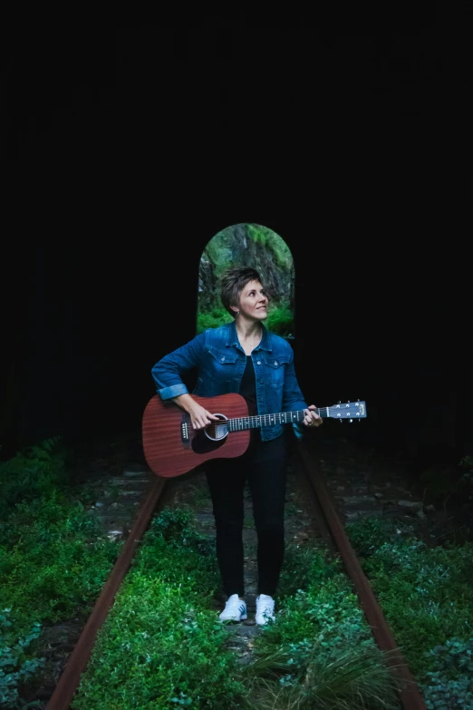 a person standing on a train track with a guitar, by Winona Nelson, standing in a dark forest, plain background, lisa brawn, profile image