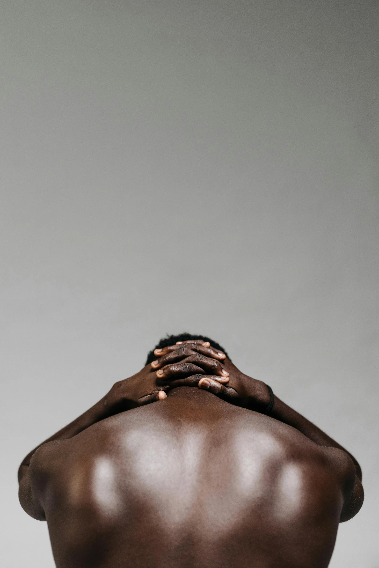 a man with his back to the camera, by Clifford Ross, darker skin, stressed expression, dark. no text, hegre
