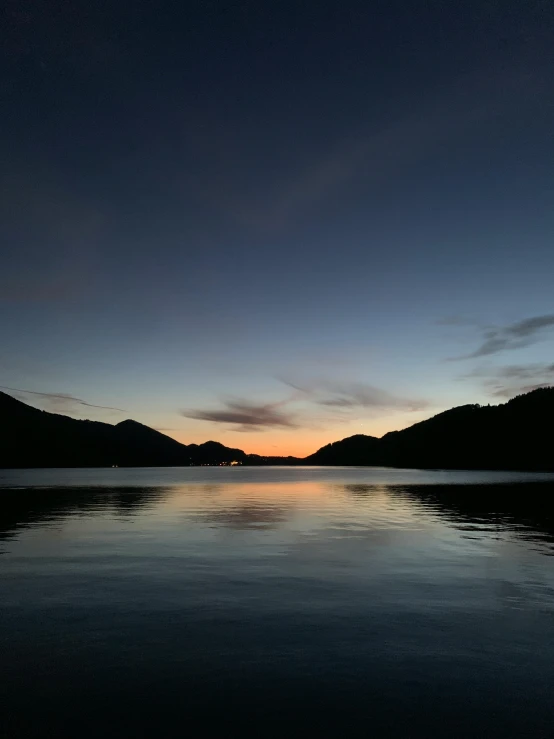 a body of water with mountains in the background, in the evening, ((sunset)), fjord, during night