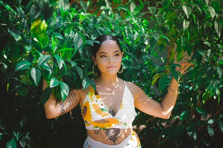 a woman posing for a picture in front of a tree, a portrait, by Andrée Ruellan, unsplash, wearing shipibo tattoos, tessa thompson inspired, wearing two - piece swimsuit, covered in plants