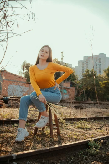 a woman sitting on top of a wooden bench, inspired by Elsa Bleda, pexels contest winner, realism, yellow clothes, wearing jeans, avatar image, in sao paulo
