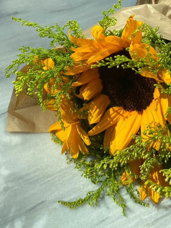 a bouquet of sunflowers sitting on a table, yellow and greens, uncropped, wrapped in flowers, full product shot