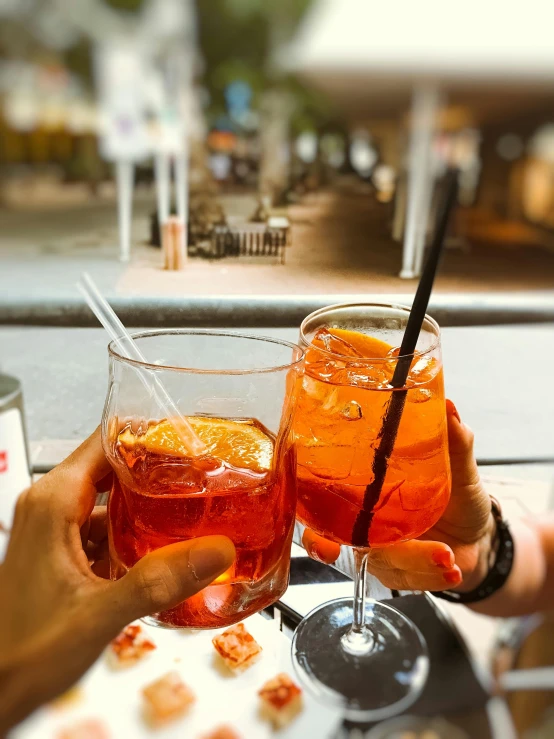 a couple of people sitting at a table with drinks, pexels contest winner, renaissance, naples, red and orange colored, 👰 🏇 ❌ 🍃, summer day