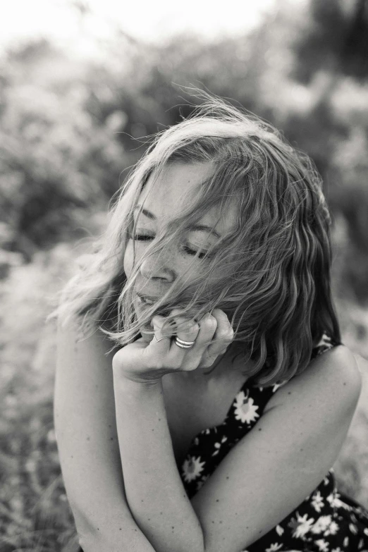 a black and white photo of a girl blowing her hair, sydney sweeney, enjoying the wind, hands on face, thoughtful )