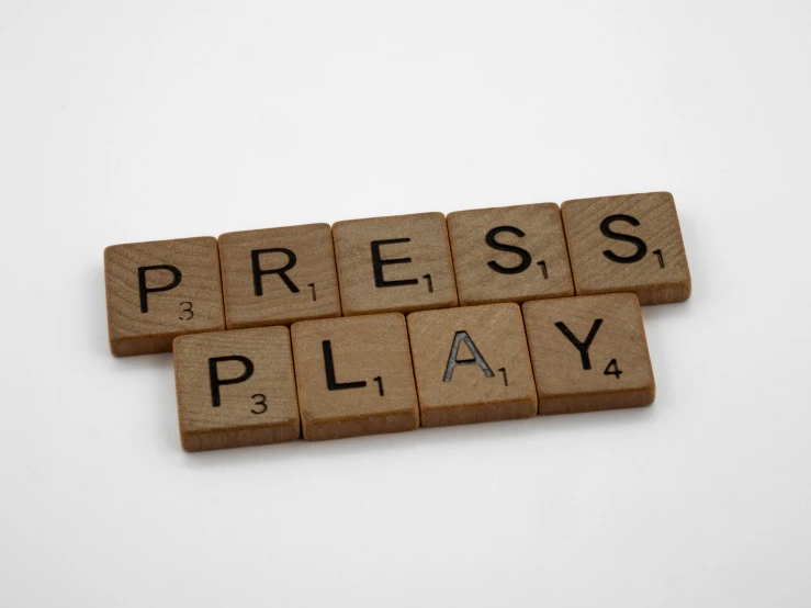 the word press play spelled with scrabbles on a white background, an album cover, by Joe Bowler, unsplash, private press, victorian newspaper article, theatre equipment, on, panel