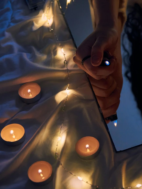 a person standing in front of a mirror with lit candles, interactive art, with sparkling gems on top, flatlay, close - up photograph, ilustration