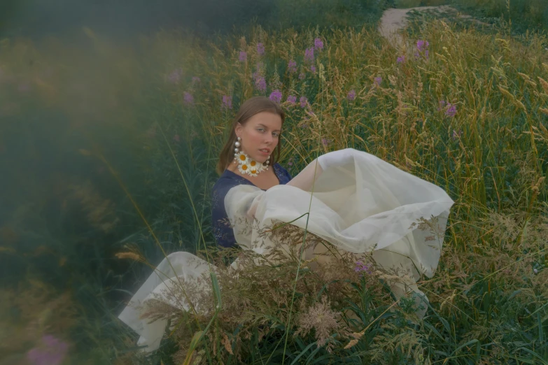 a woman sitting in a field of tall grass, an album cover, inspired by Anna Füssli, flowers around, modeled, ignant, item